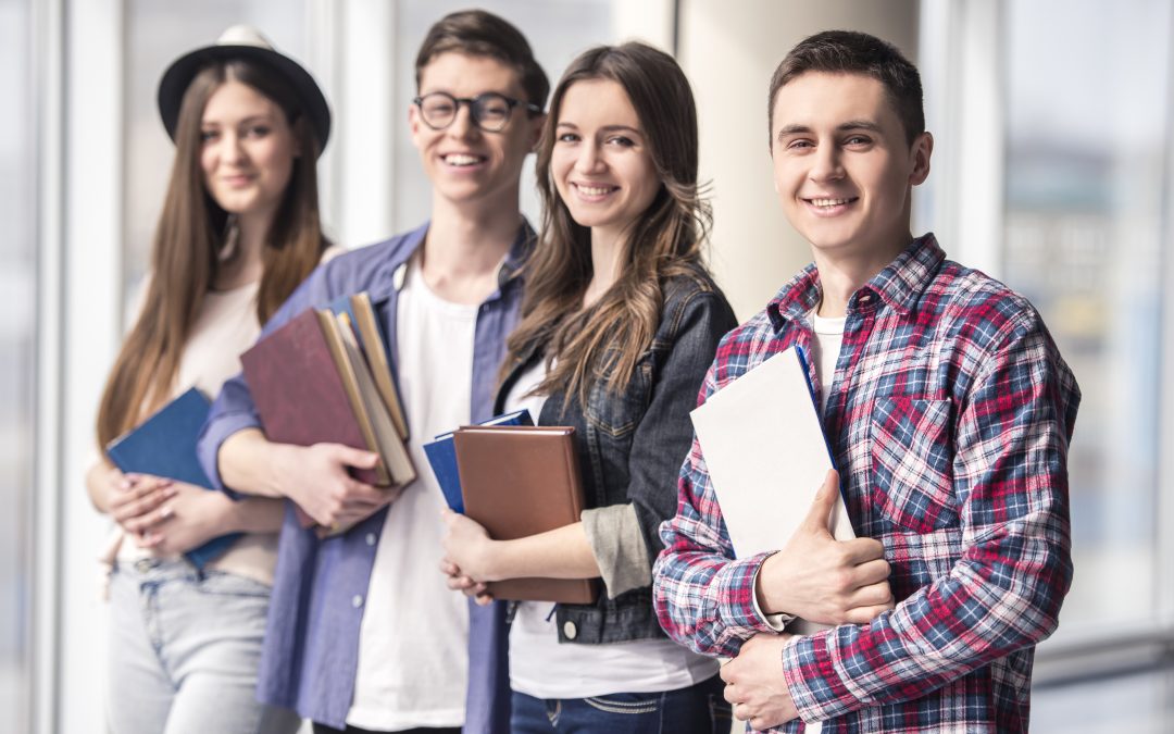 group of happy young students in university