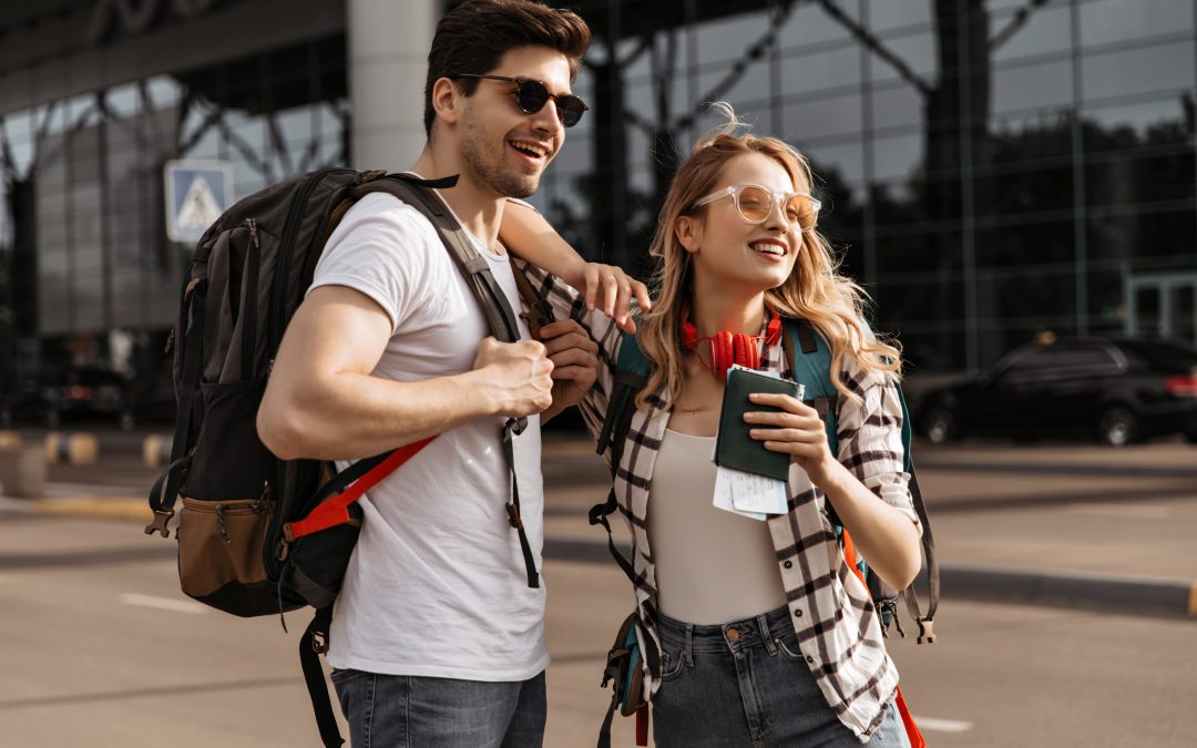 travelers with backpacks poses near modern airport